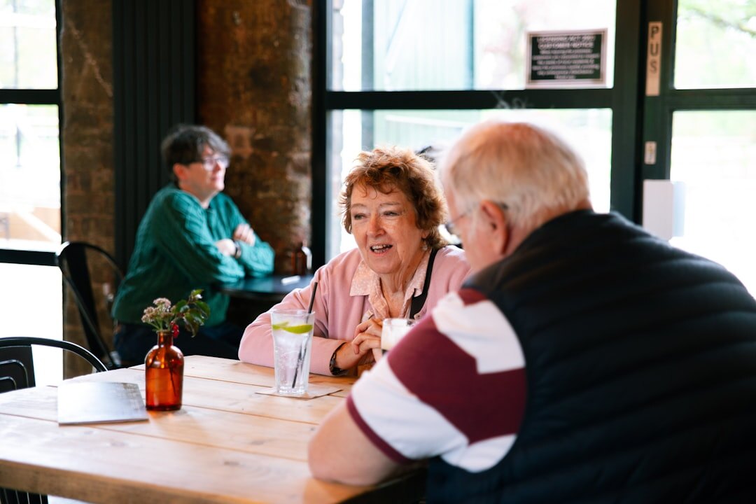 Slovak senior friends sitting together at a cafe table laughing